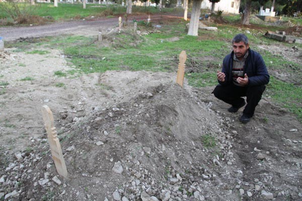 Cep telefonu ve kıyafetleriyle gömüldü